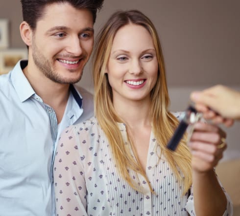 image of a couple receiving a set of keys, they take the keys knowing that they are covered by the best Renters' Insurance policy in Columbia, SC